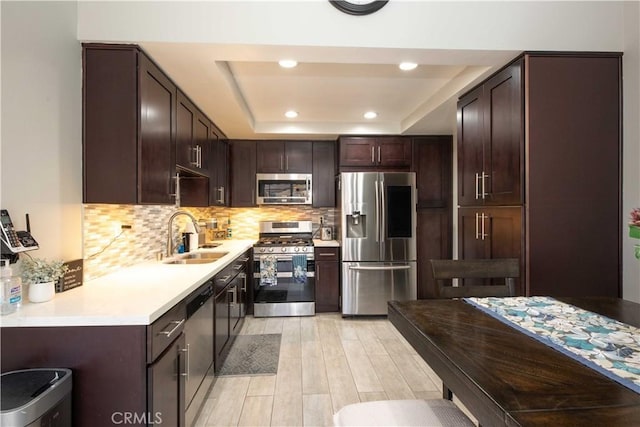 10546 Royal Oak Way, Stanton, CA 90680 - kitchen featuring stainless steel appliances, light wood finished floors, dark brown cabinets, a tray ceiling, and light countertops
