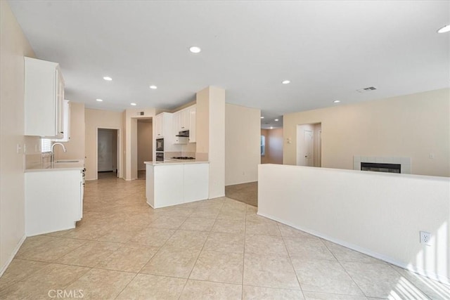 36340 Sicily Ln, Winchester, CA 92596 - kitchen with open floor plan, white cabinets, a tiled fireplace, light countertops, and recessed lighting