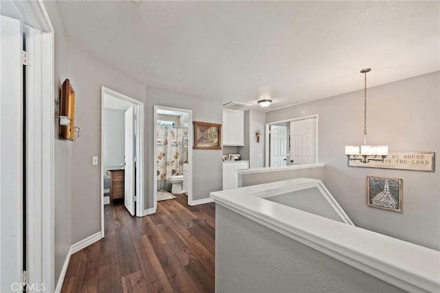 9081 Mandarin Ln, Riverside, CA 92508 - hall featuring separate washer and dryer, dark wood-style flooring, a chandelier, and baseboards