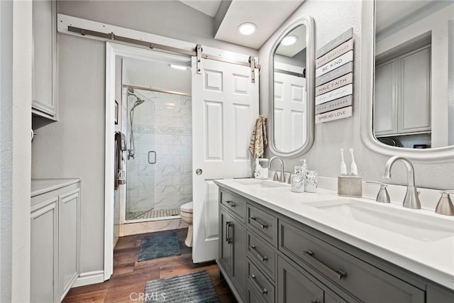 9081 Mandarin Ln, Riverside, CA 92508 - full bathroom with double vanity, a shower stall, toilet, and wood finished floors