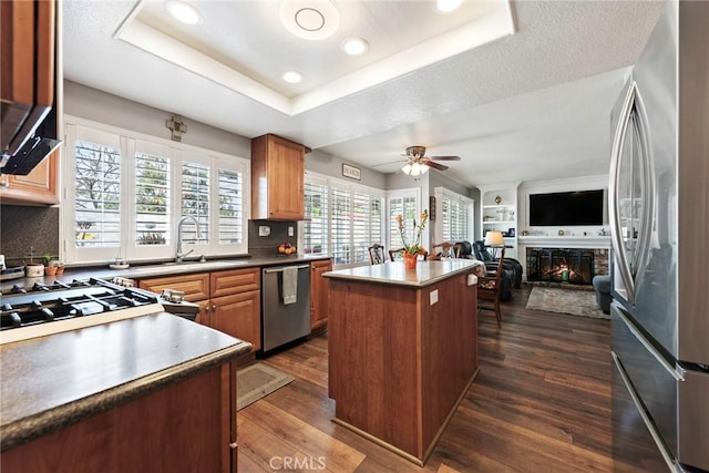9081 Mandarin Ln, Riverside, CA 92508 - kitchen with stainless steel appliances, a ceiling fan, a kitchen island, dark wood-style flooring, and open floor plan