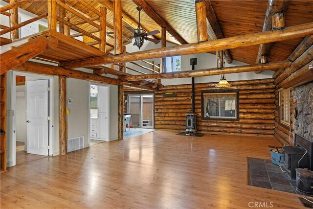 30771 Fox Ridge Ct, Tehachapi, CA 93561 - unfurnished living room with a wood stove, rustic walls, high vaulted ceiling, wood ceiling with exposed beams, and wood finished floors