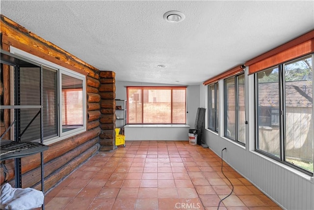 30771 Fox Ridge Ct, Tehachapi, CA 93561 - unfurnished sunroom featuring rustic walls, a textured ceiling, and tile patterned floors