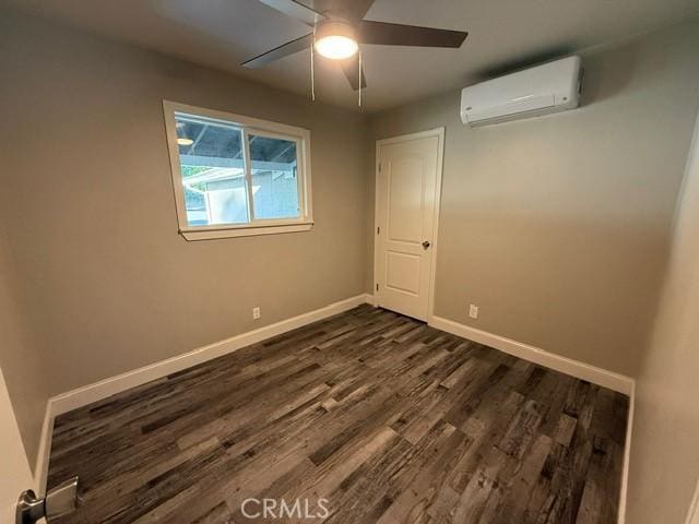 2911 Rancho Vista Dr, Lucerne, CA 95458 - empty room with a wall unit AC, dark wood-style flooring, baseboards, and ceiling fan