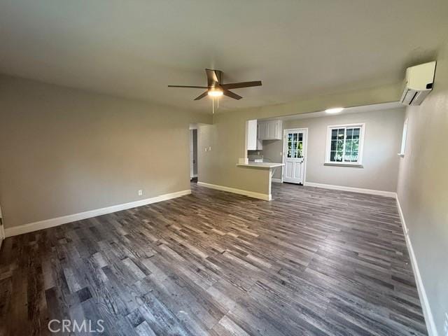 2911 Rancho Vista Dr, Lucerne, CA 95458 - unfurnished living room with an AC wall unit, dark wood-style floors, a ceiling fan, and baseboards