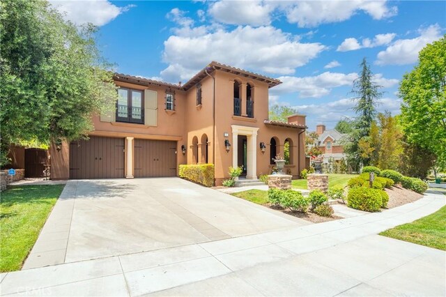 15 Basilica Pl, Ladera Ranch, CA 92694 - mediterranean / spanish home with an attached garage, concrete driveway, stucco siding, a tiled roof, and a front lawn