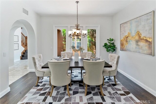 15 Basilica Pl, Ladera Ranch, CA 92694 - dining space with stairs, a chandelier, dark wood finished floors, arched walkways, and baseboards