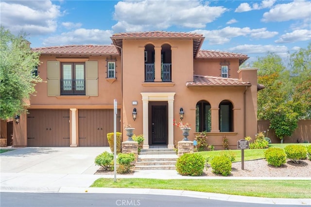 15 Basilica Pl, Ladera Ranch, CA 92694 - mediterranean / spanish-style house with a balcony, a tiled roof, a garage, driveway, and stucco siding