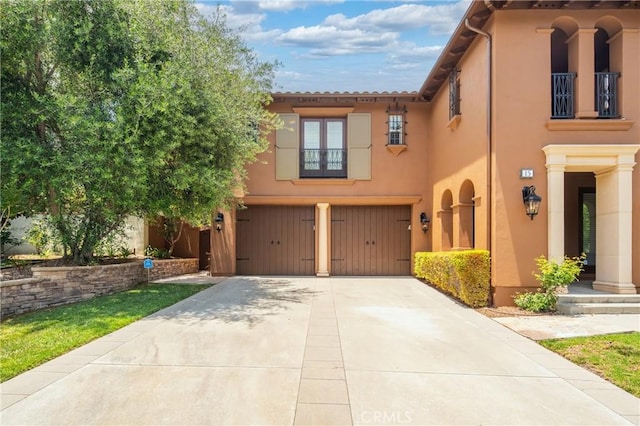 15 Basilica Pl, Ladera Ranch, CA 92694 - mediterranean / spanish home featuring a garage, driveway, stucco siding, and a balcony