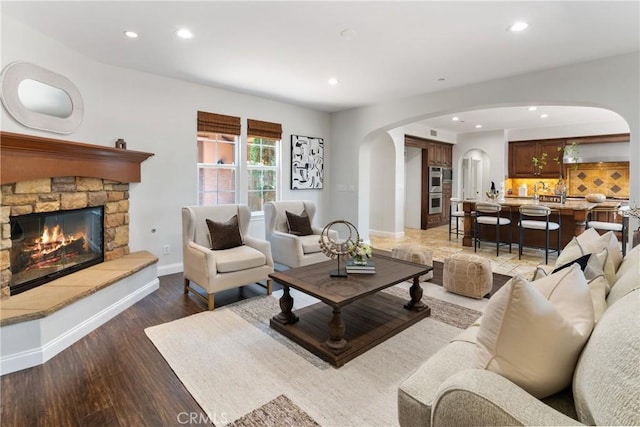 15 Basilica Pl, Ladera Ranch, CA 92694 - living area with arched walkways, recessed lighting, a fireplace, baseboards, and wood finished floors