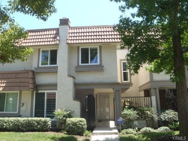 11459 Shippigan Way, Cypress, CA 90630 - view of front facade featuring stucco siding, a tile roof, a chimney, and mansard roof