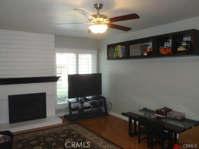 11459 Shippigan Way, Cypress, CA 90630 - living room with wood finished floors, a ceiling fan, a large fireplace, and baseboards