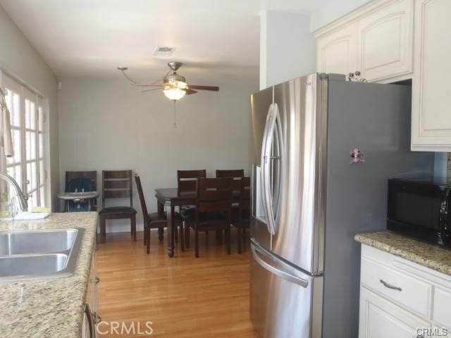 11459 Shippigan Way, Cypress, CA 90630 - kitchen with a sink, stainless steel fridge with ice dispenser, black microwave, a ceiling fan, and light wood finished floors