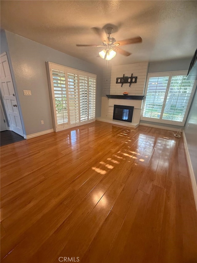 11459 Shippigan Way, Cypress, CA 90630 - unfurnished living room with ceiling fan, a textured ceiling, wood finished floors, and a brick fireplace