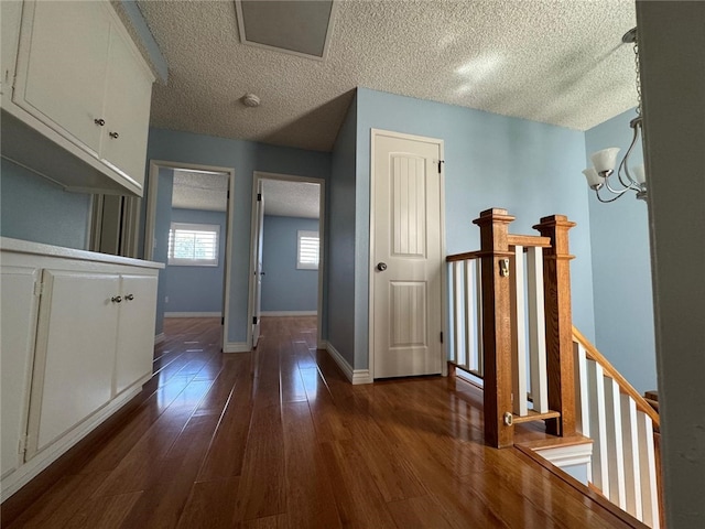 11459 Shippigan Way, Cypress, CA 90630 - corridor with an upstairs landing, a textured ceiling, dark wood-style flooring, and a chandelier