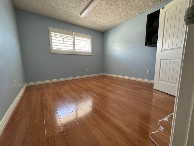 11459 Shippigan Way, Cypress, CA 90630 - spare room featuring wood finished floors, a wall unit AC, and a textured ceiling