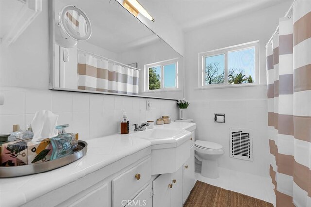 1330 N Crescent Heights Blvd Unit 12, West Hollywood, CA 90046 - bathroom with double vanity, tile walls, toilet, a shower with shower curtain, and decorative backsplash