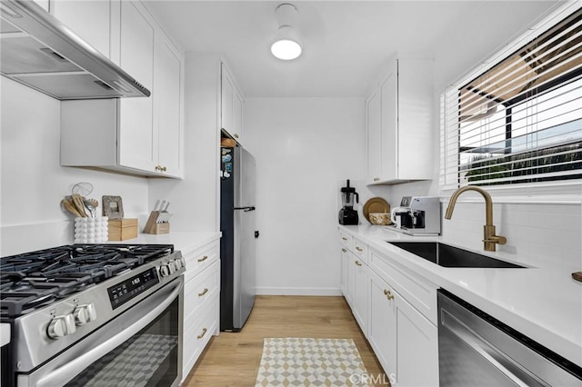 1330 N Crescent Heights Blvd Unit 12, West Hollywood, CA 90046 - kitchen featuring appliances with stainless steel finishes, ventilation hood, a sink, light countertops, and white cabinets