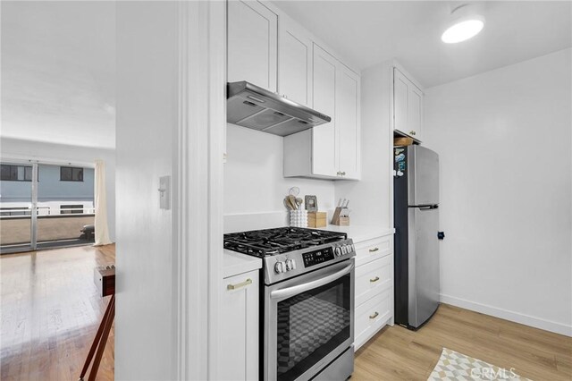 1330 N Crescent Heights Blvd Unit 12, West Hollywood, CA 90046 - kitchen with stainless steel appliances, under cabinet range hood, light wood finished floors, white cabinets, and light countertops