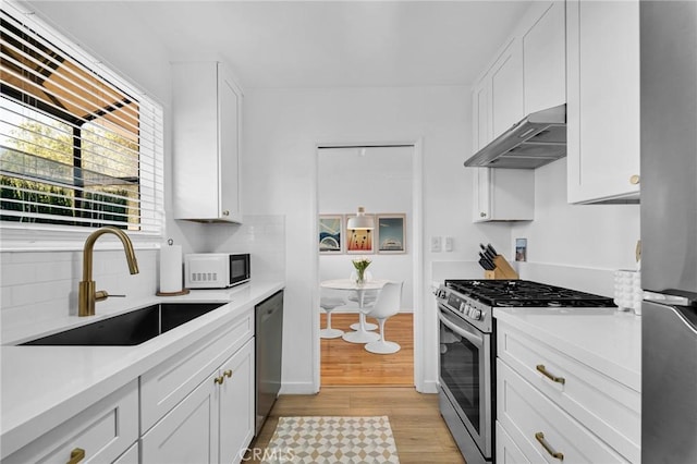 1330 N Crescent Heights Blvd Unit 12, West Hollywood, CA 90046 - kitchen featuring appliances with stainless steel finishes, under cabinet range hood, a sink, and light countertops