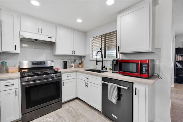 18064 Cajon St, Hesperia, CA 92345 - kitchen featuring appliances with stainless steel finishes, under cabinet range hood, a sink, light wood-style flooring, and white cabinetry