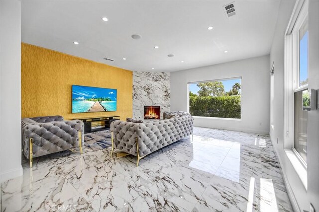 9743 Monogram Ave, Northridge, CA 91343 - living room with recessed lighting, marble tiled floors, an accent wall, and a fireplace