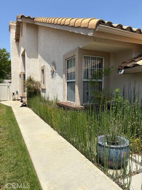 1041 Cypress Point Dr, Banning, CA 92220 - view of home's exterior featuring stucco siding and a tile roof