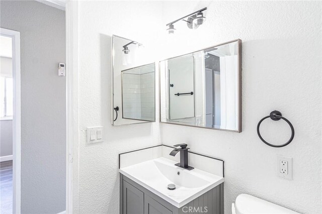 2008 Sequoia Dr, Barstow, CA 92311 - bathroom featuring vanity, toilet, and a textured wall