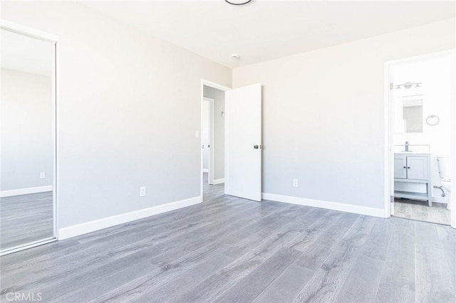 2008 Sequoia Dr, Barstow, CA 92311 - unfurnished bedroom featuring wood finished floors, baseboards, and ensuite bath