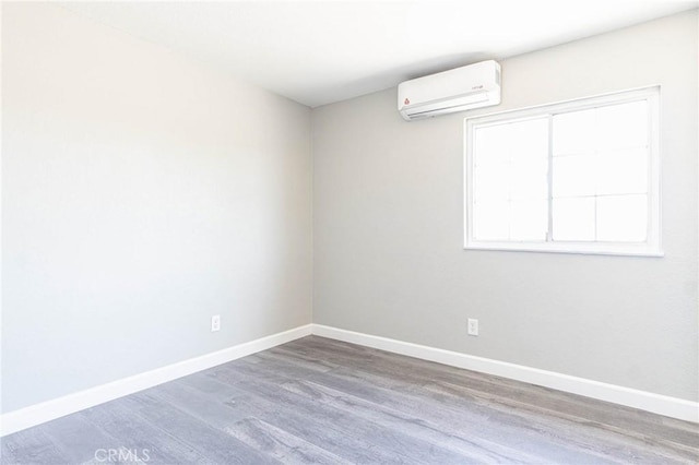 2008 Sequoia Dr, Barstow, CA 92311 - empty room with a wall mounted air conditioner, baseboards, and wood finished floors