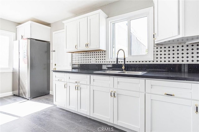 2008 Sequoia Dr, Barstow, CA 92311 - kitchen featuring freestanding refrigerator, a sink, dark countertops, and white cabinets