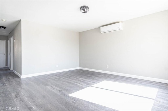 2008 Sequoia Dr, Barstow, CA 92311 - unfurnished room with an AC wall unit, wood finished floors, and baseboards