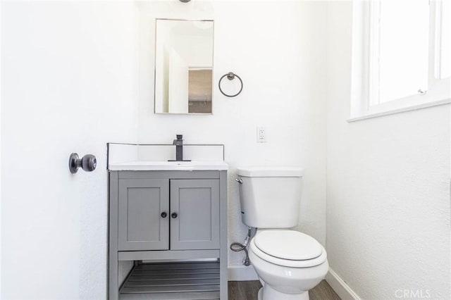 2008 Sequoia Dr, Barstow, CA 92311 - half bathroom with toilet, baseboards, vanity, and wood finished floors