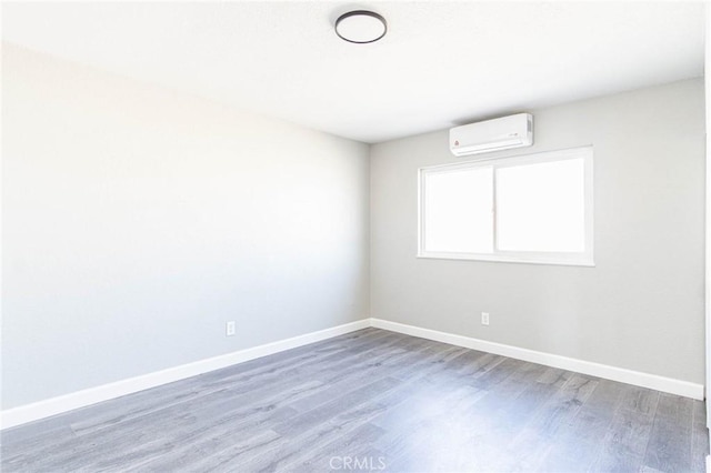 2008 Sequoia Dr, Barstow, CA 92311 - unfurnished room featuring a wall unit AC, wood finished floors, and baseboards