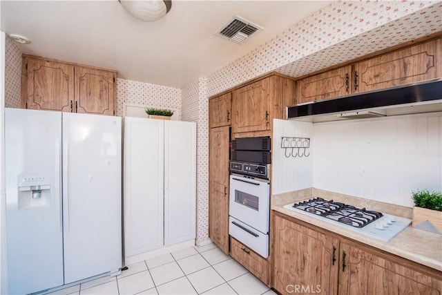 3328 La Puente Rd, West Covina, CA 91792 - kitchen featuring white appliances, wallpapered walls, a warming drawer, light countertops, and brown cabinetry