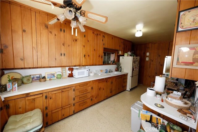 6441 Varna Ave, Valley Glen, CA 91401 - kitchen with white appliances, a sink, a ceiling fan, brown cabinets, and wooden walls