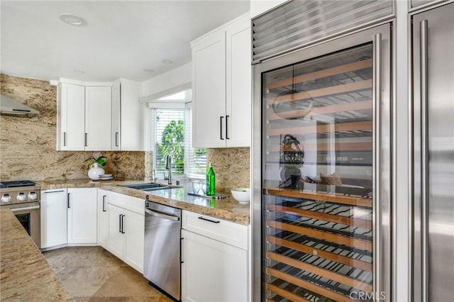 245 Palmer St, Costa Mesa, CA 92627 - kitchen with stainless steel appliances, a sink, beverage cooler, backsplash, and white cabinets