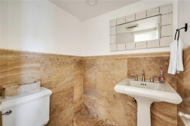 245 Palmer St, Costa Mesa, CA 92627 - bathroom with toilet, tile walls, a wainscoted wall, and a sink