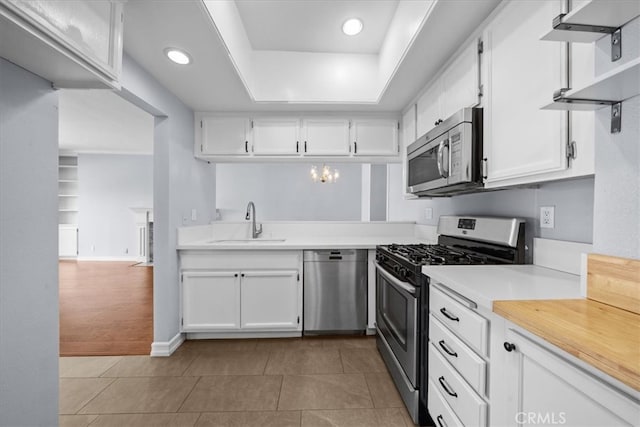3568 Keystone Ave Unit 8, Los Angeles, CA 90034 - kitchen featuring appliances with stainless steel finishes, a sink, a tray ceiling, light countertops, and white cabinets