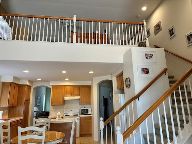 35419 El Diamante Dr, Wildomar, CA 92595 - kitchen featuring white appliances, arched walkways, under cabinet range hood, recessed lighting, and light countertops