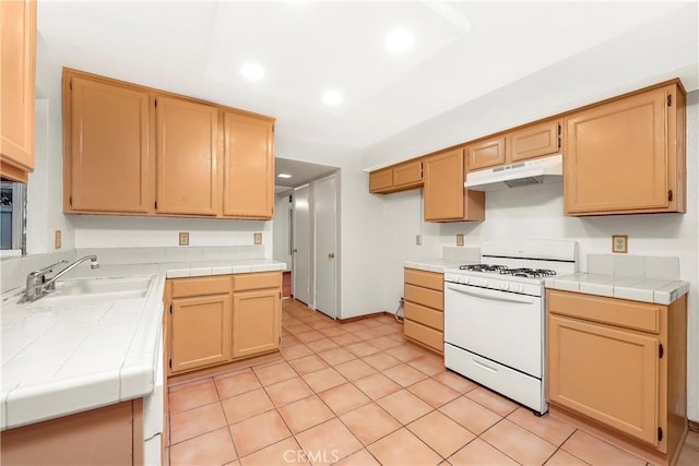 37538 Stonegate Ln, Palmdale, CA 93552 - kitchen featuring white range with gas stovetop, a sink, tile countertops, under cabinet range hood, and recessed lighting