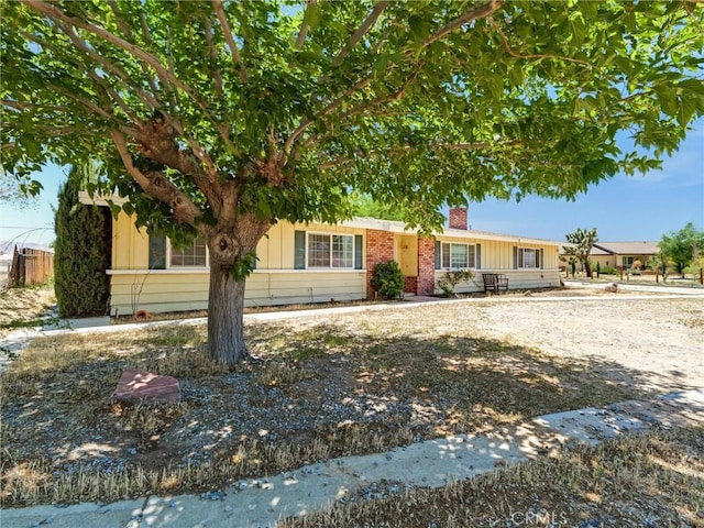 20715 Teton Rd, Apple Valley, CA 92308 - view of front of house with a chimney, board and batten siding, and brick siding