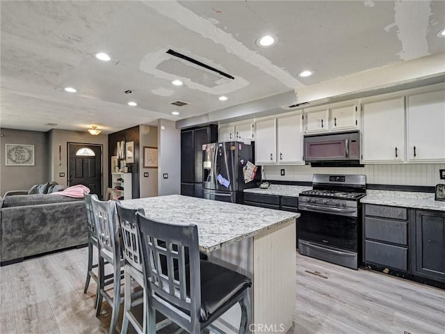 20715 Teton Rd, Apple Valley, CA 92308 - kitchen featuring appliances with stainless steel finishes, light wood-type flooring, open floor plan, a breakfast bar area, and recessed lighting