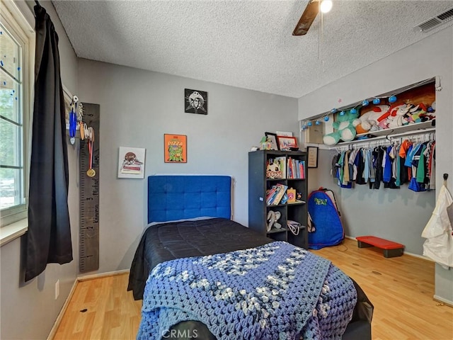 20715 Teton Rd, Apple Valley, CA 92308 - bedroom with wood finished floors, a textured ceiling, a closet, and ceiling fan