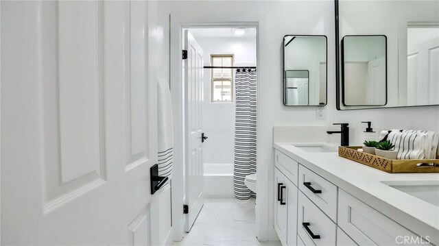 53 Via Armilla, San Clemente, CA 92673 - bathroom featuring double vanity, shower / tub combo with curtain, and marble look tiles