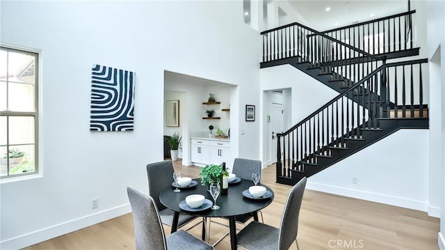53 Via Armilla, San Clemente, CA 92673 - dining area featuring stairs, light wood-style flooring, baseboards, plenty of natural light, and a towering ceiling