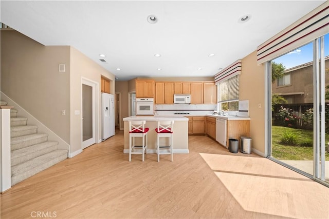 7343 Legacy Pl, Rancho Cucamonga, CA 91730 - kitchen with white appliances, light countertops, a kitchen island, light wood-style flooring, and light brown cabinetry