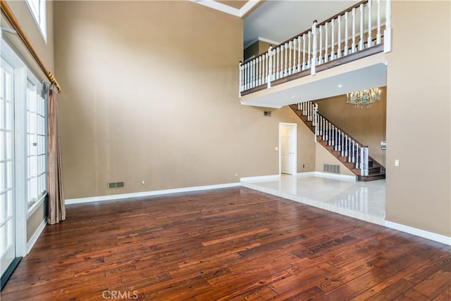 29515 Weeping Willow Dr, Agoura Hills, CA 91301 - unfurnished living room featuring wood-type flooring, stairway, a towering ceiling, baseboards, and a chandelier