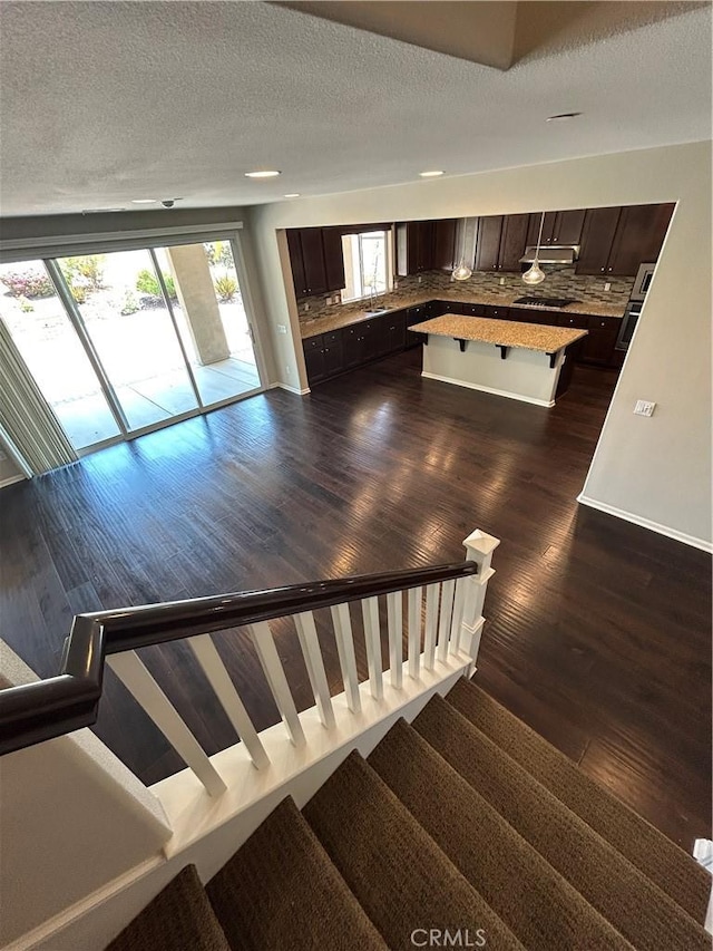 17426 Fairbreeze Ct, Riverside, CA 92504 - stairs with wood finished floors, a textured ceiling, and baseboards