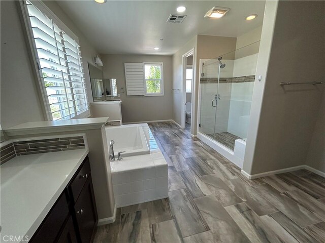 17426 Fairbreeze Ct, Riverside, CA 92504 - full bath with a stall shower, a bath, vanity, toilet, and recessed lighting